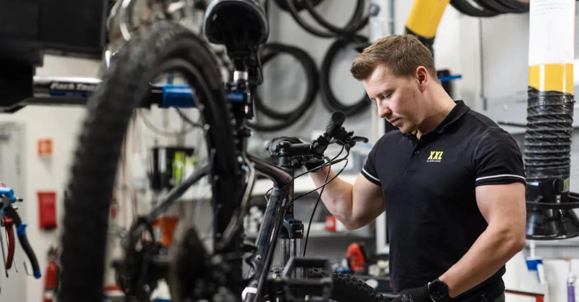 En sykkelmekaniker fra XXL utfører en service på en sykkel til en Wanda-kunde