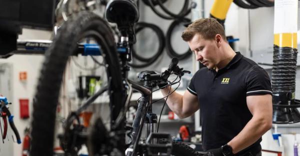 En sykkelmekaniker fra XXL utfører en service på en sykkel til en Wanda-kunde